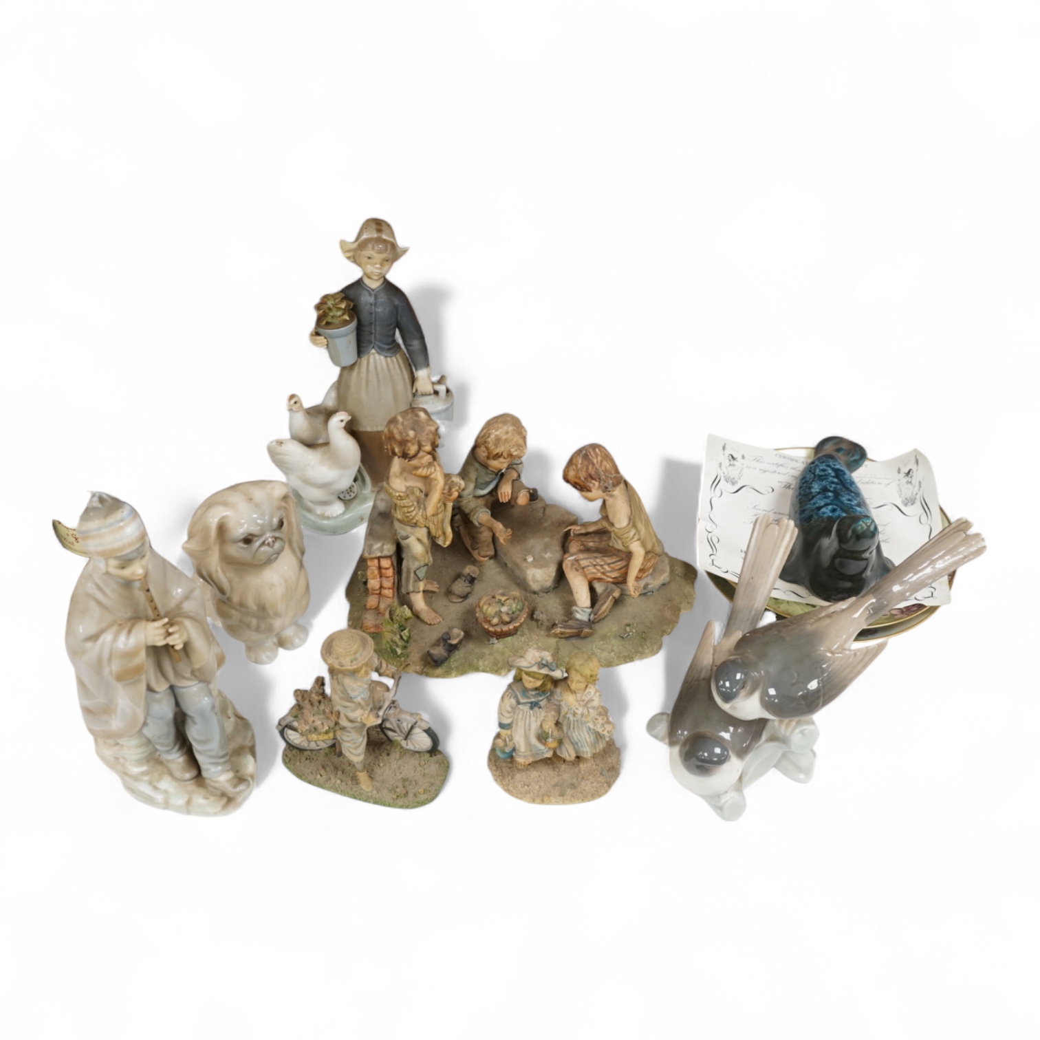 A collection of pottery and porcelain to include a Hayle model of a seal, Lladro figures and a pair of Fairy cabinet plates, largest 27cm wide